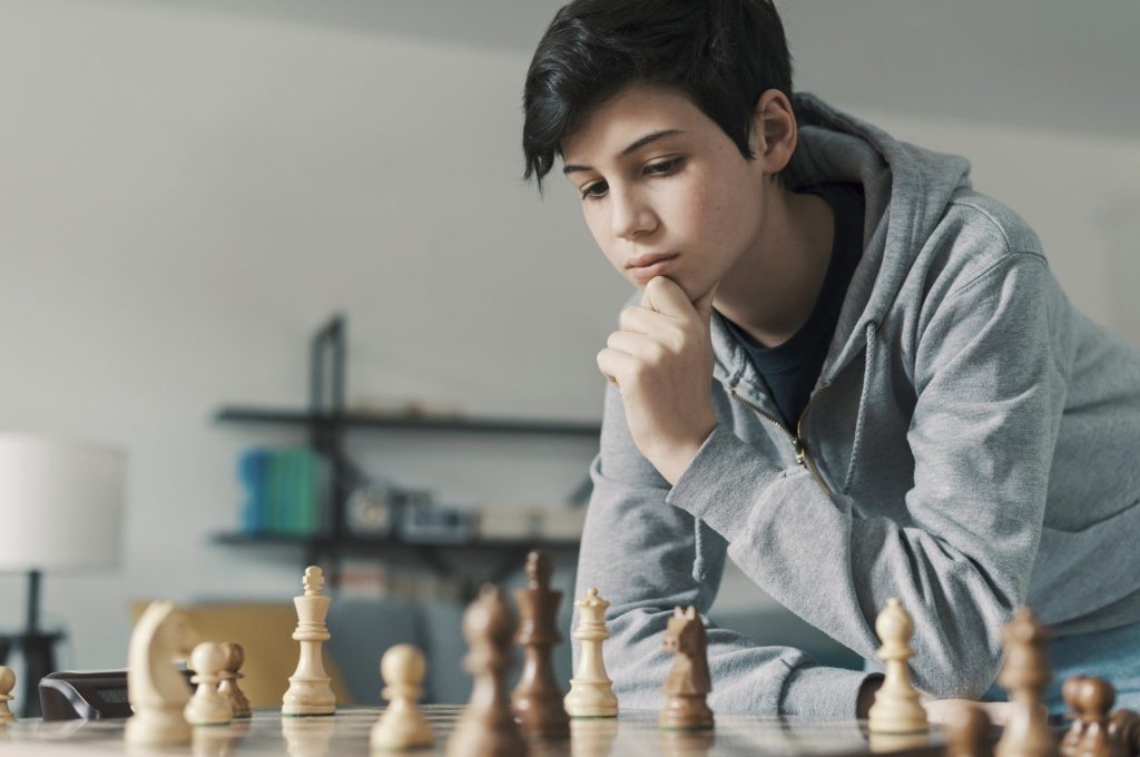 smart-boy-playing-chess-and-staring-at-the-chessboard-e1650508379344.jpg